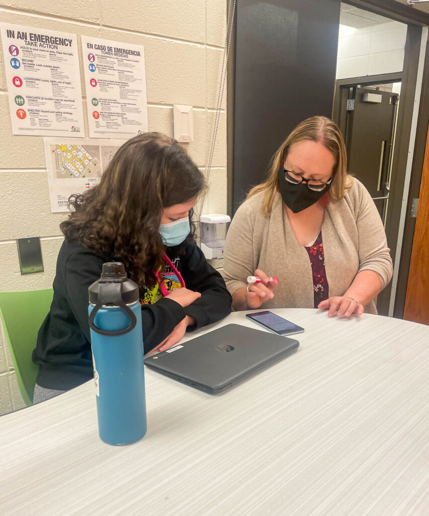 New Meridian High senior Jeanne Gochenour works with teacher during class.